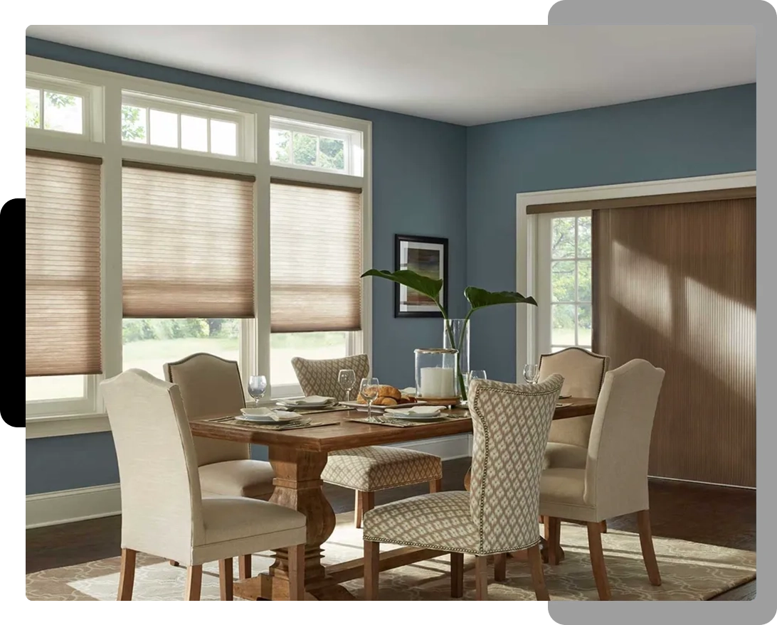 A dining room with a table and chairs, and several windows.