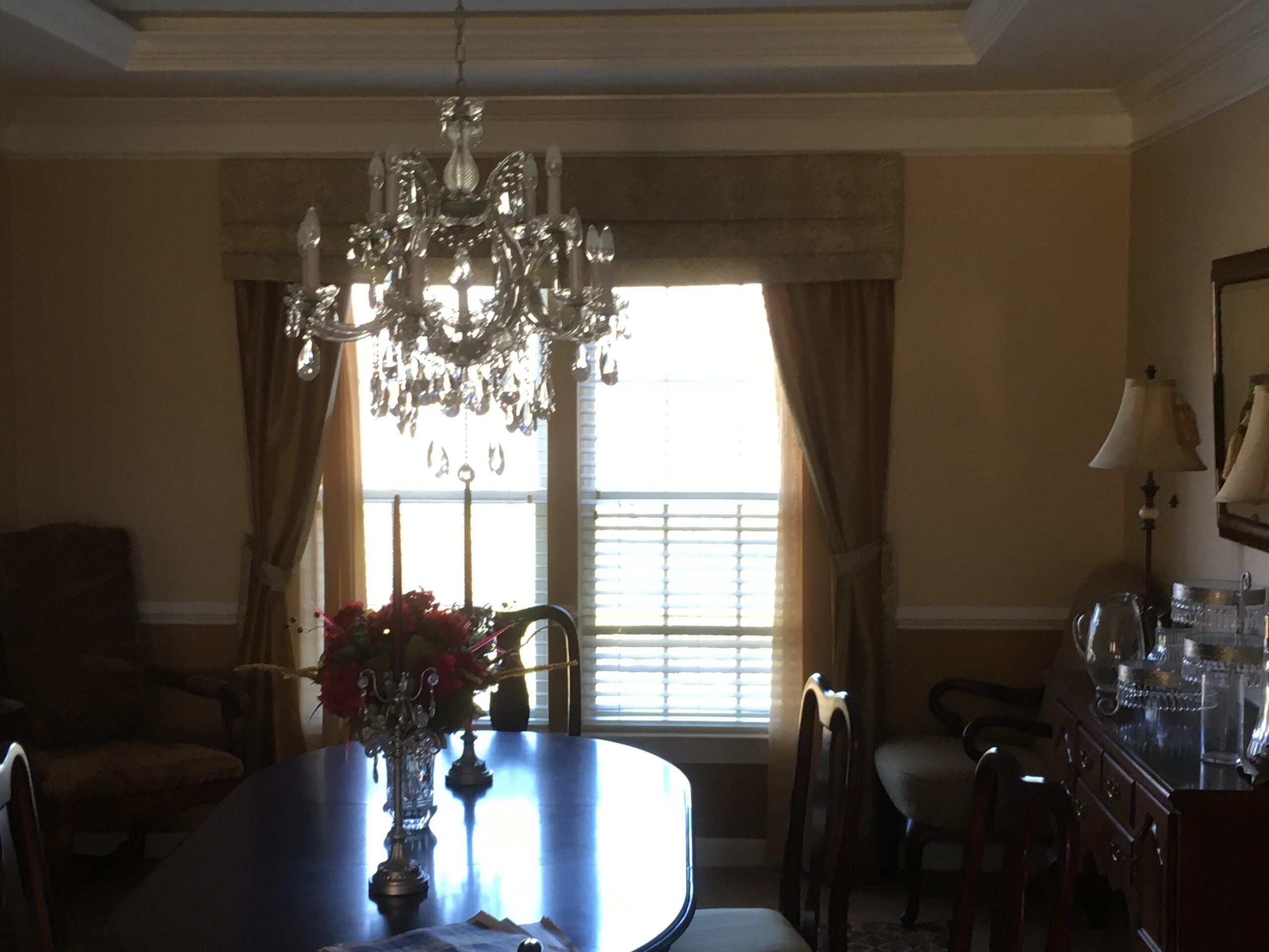 A dining room table with flowers in the center.