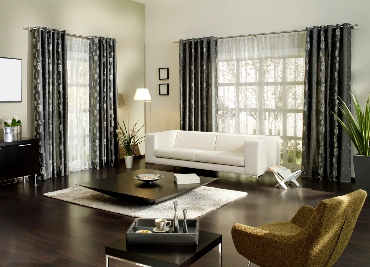 A living room with white furniture and black curtains.